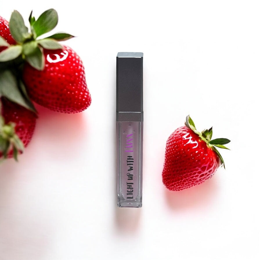 Sophisticated Strawberry Lip Gloss with fresh strawberries on white background.