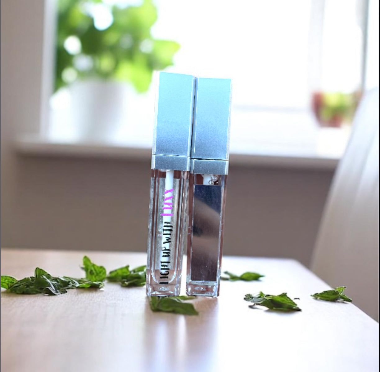 Majestic Mint Lip Gloss with refreshing mint leaves in a bright room setting.